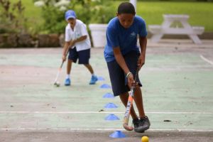 Students playing field hockey at Codrington School in Barbados
